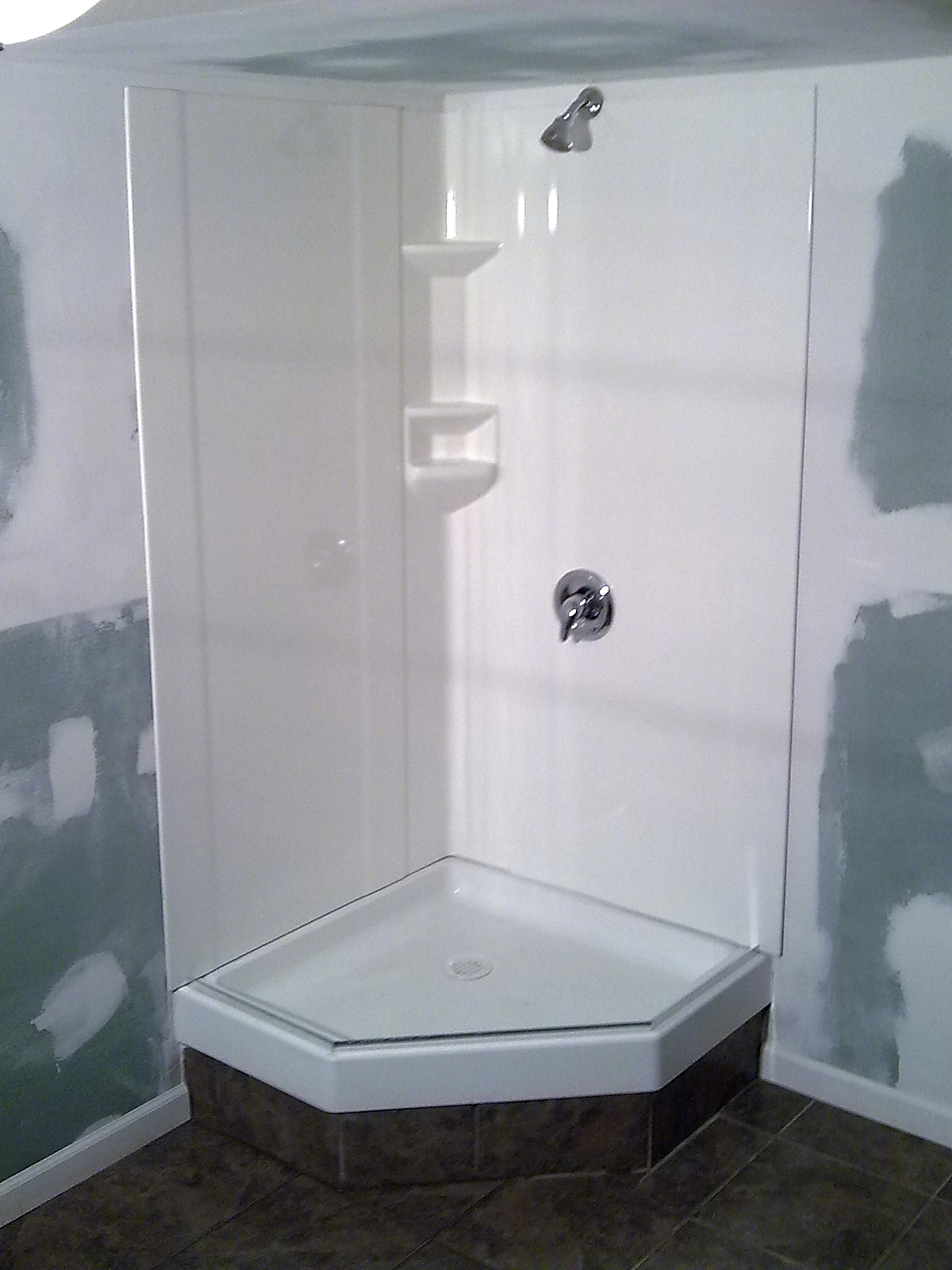 Corner basement shower enclosure.
